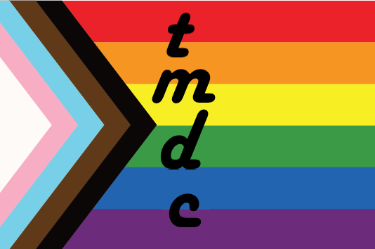 A “philly” pride flag made up of alternating rainbow stripes (red orange yellow green dark blue violet) and a right chevron made up of alternating colors (white pink light blue brown black). The letters ‘tmdc’ are superimposed in black. (CC-BY-NC)